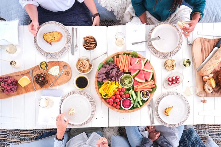 a group of people sitting at a table with a cake