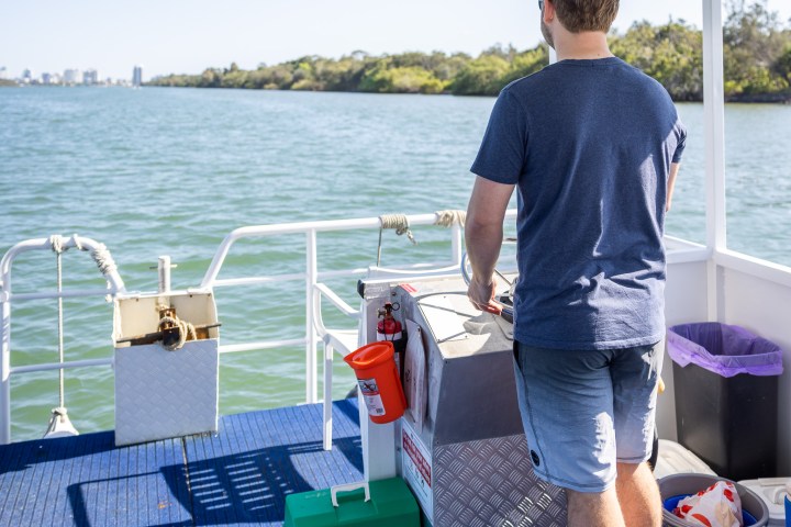 a man standing next to a body of water