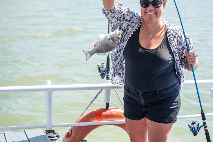 a woman standing next to a body of water