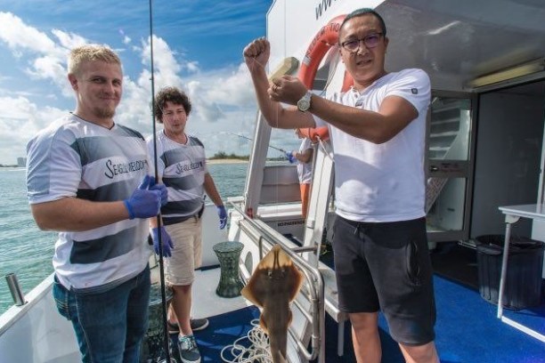 a person holding a fish in the water