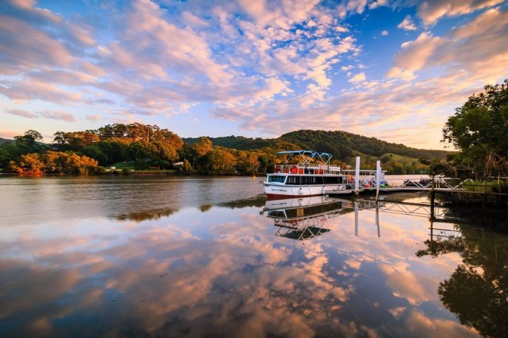 a boat traveling along a river next to a body of water