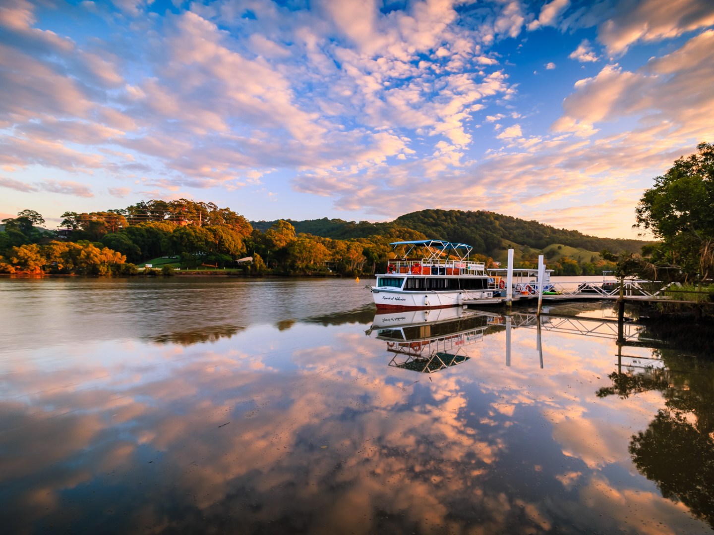 a boat traveling along a river next to a body of water