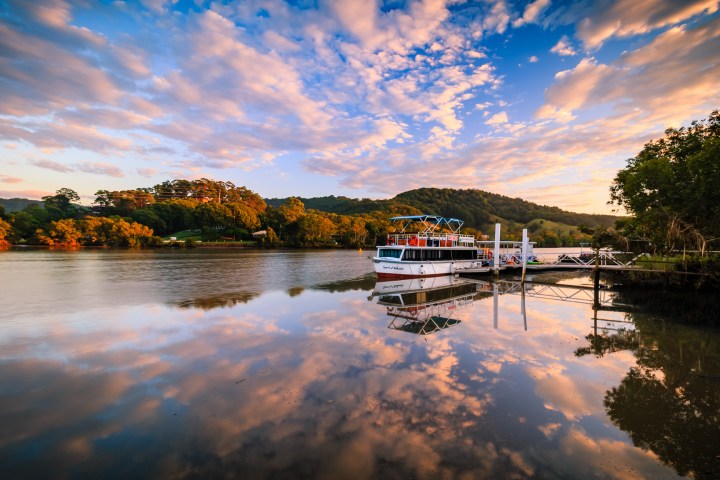 a boat traveling along a river next to a body of water