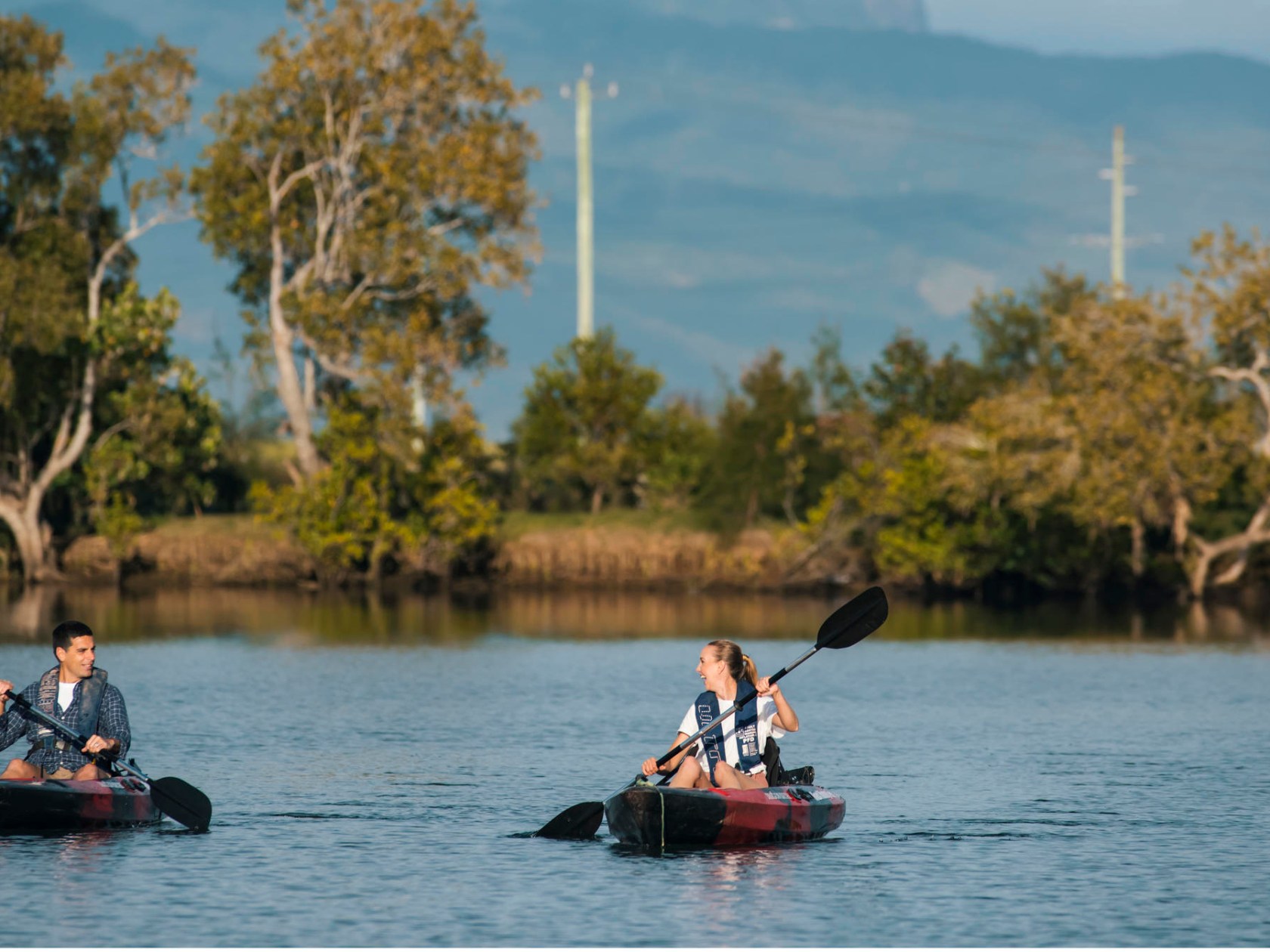 a group of people rowing a boat floating on a body of water