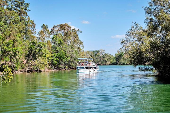 a small boat in a body of water surrounded by trees