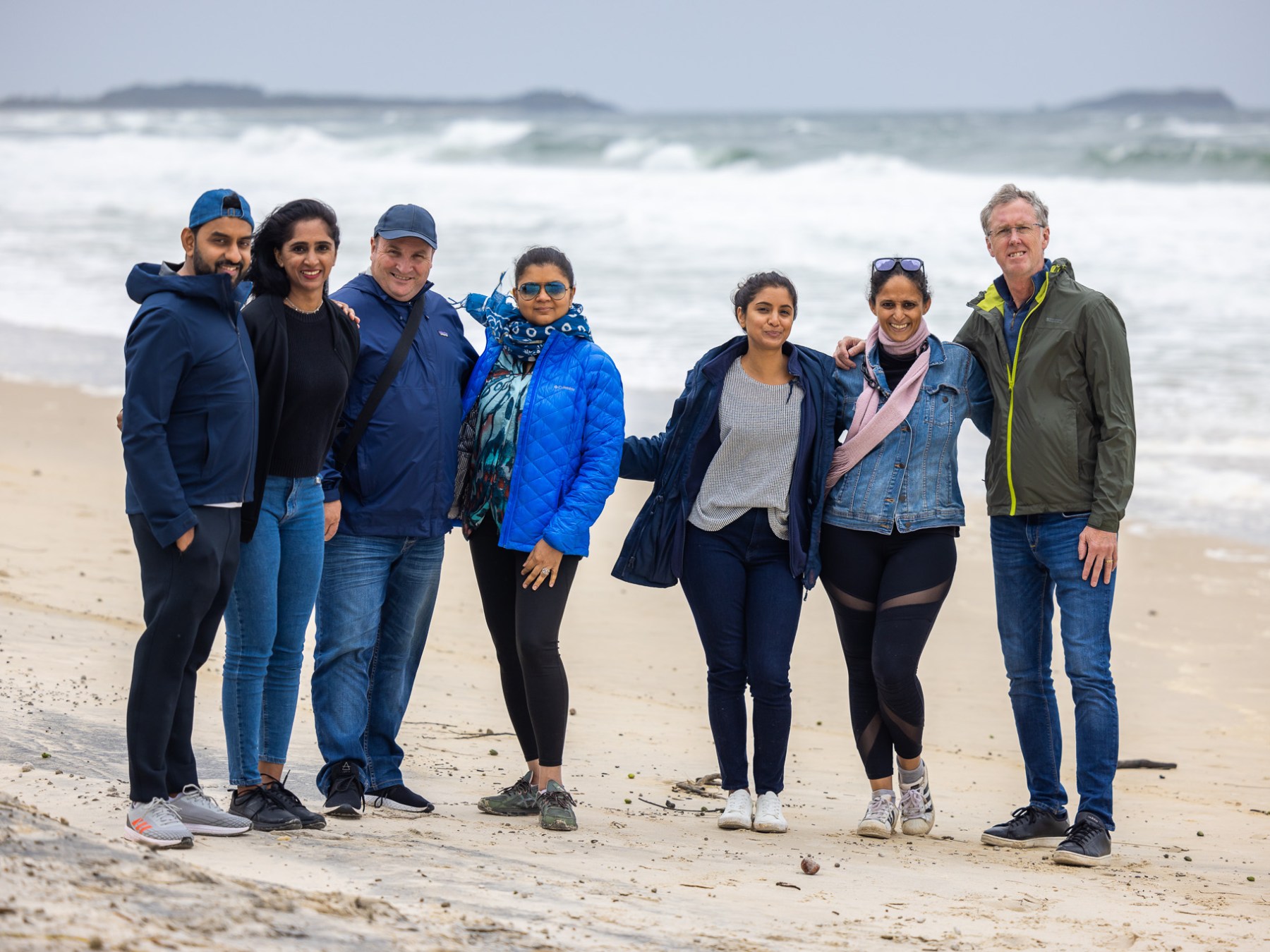 a group of people on a beach posing for the camera