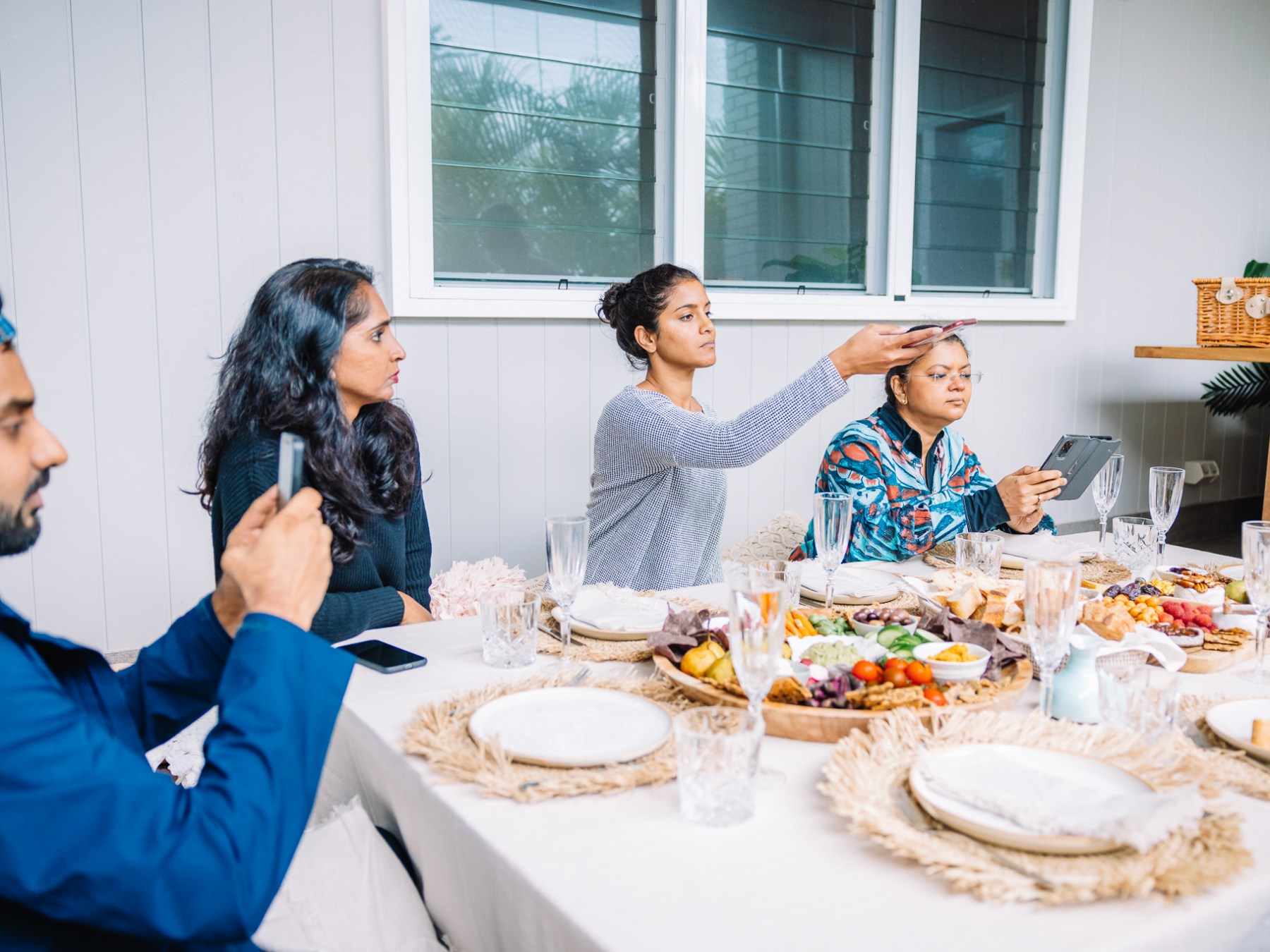 a group of people sitting at a table with a plate of food